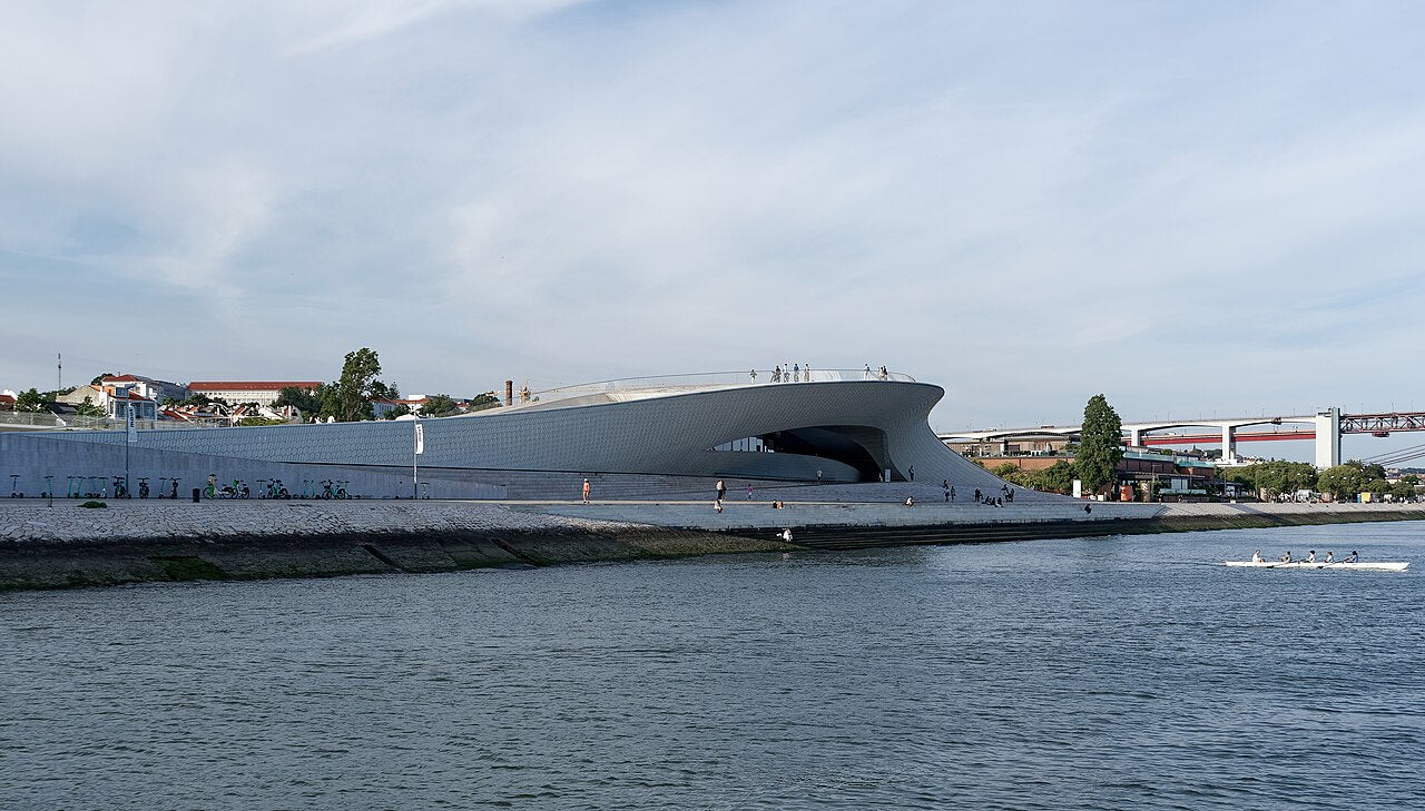 MAAT — Museum of Art, Architecture and Technology in Lisbon at dusk, wave-form ceramic façade beside the Tagus River
